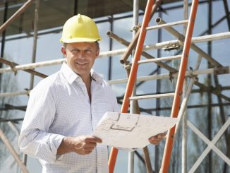Architect Studying Plans Outside New Home